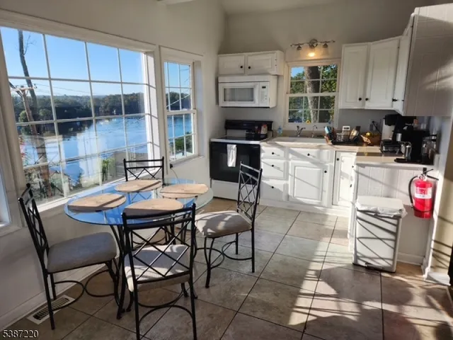 a kitchen with a dining table chairs and a stove top oven