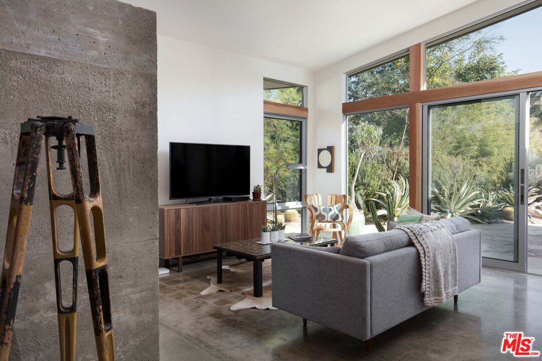7500 Devista Drive Los Angeles, CA 90046 - Photo 14 of 43 a living room with furniture a flat screen tv and a floor to ceiling window