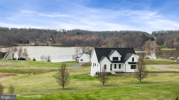 a view of a lake with a big yard and large trees