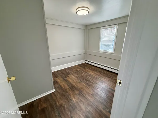 a view of empty room with wooden floor