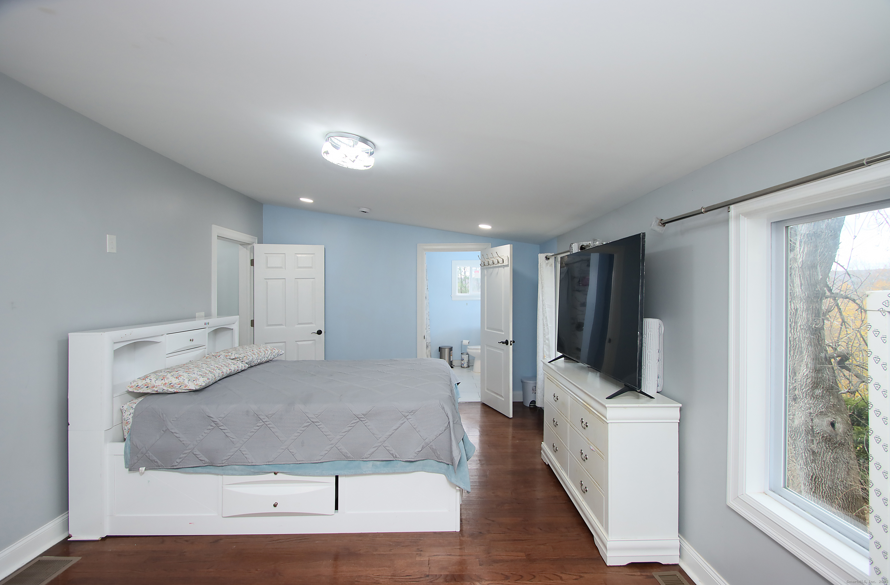 32 Spring Street Ansonia, CT 06401 - Photo 14 of 34 a large white room with a large window and a flat screen tv