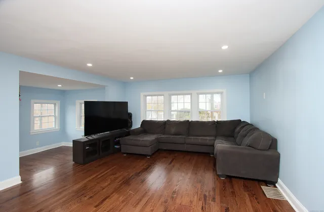 a living room with furniture a wooden floor and a window