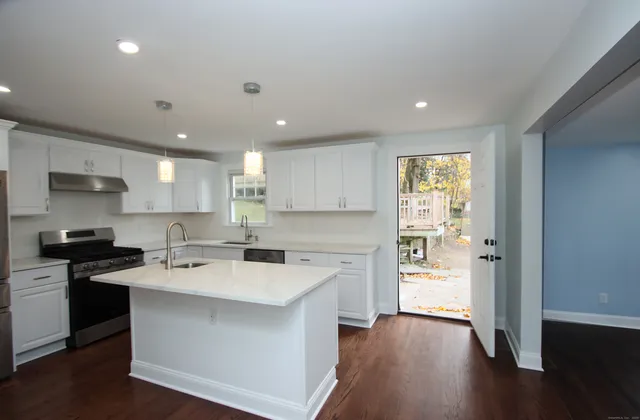 a kitchen with a sink a stove a refrigerator and a microwave