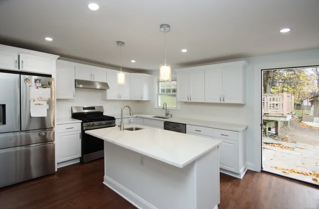 a kitchen that has a sink a stove and a refrigerator