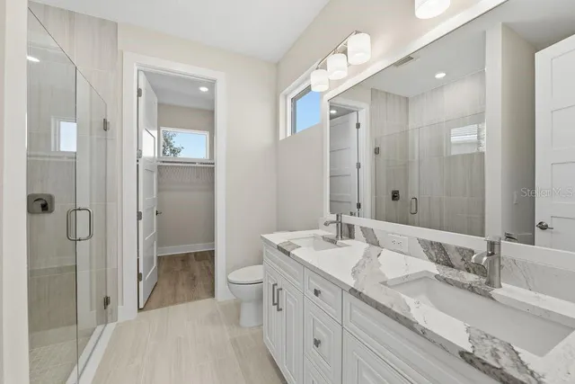 a spacious bathroom with a double vanity sink mirror double and shower