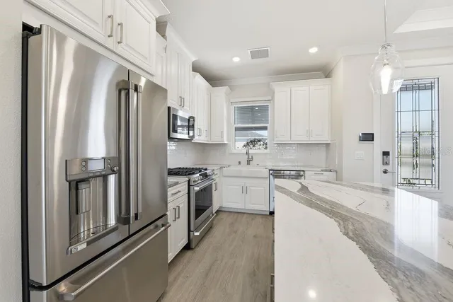 a kitchen with stainless steel appliances granite countertop a refrigerator sink and stove