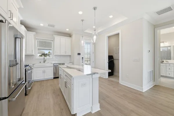 a kitchen with white cabinets and white appliances