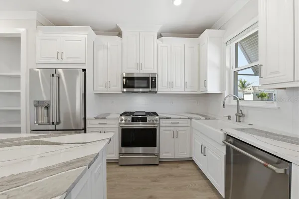a kitchen with stainless steel appliances granite countertop a stove a sink and a refrigerator