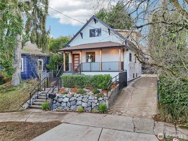 a front view of a house with a yard and potted plants