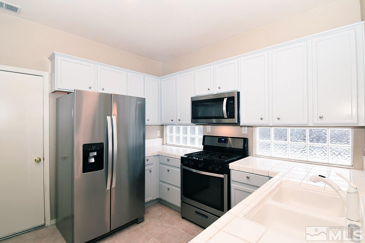 1100 Scenic Park Terrace Reno, NV 89521 - Photo 6 of 34 a kitchen with a refrigerator stove and microwave