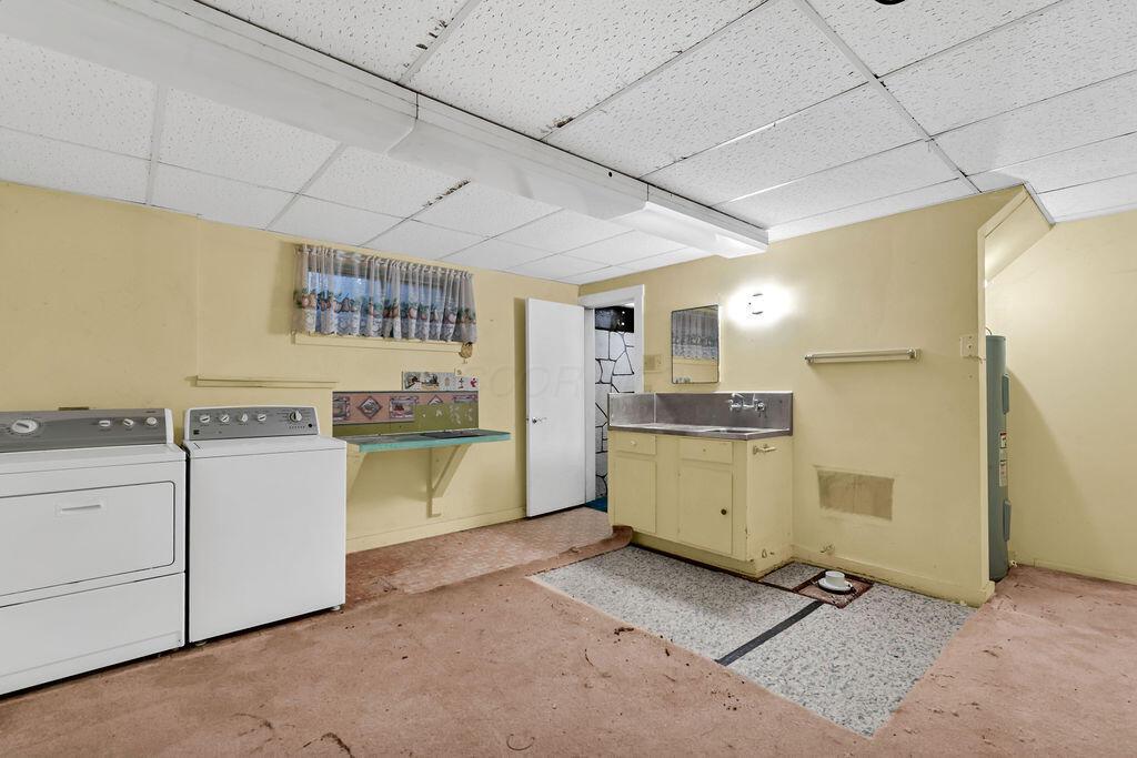 4409 Newton Road Northeast Newark, OH 43055 - Photo 66 of 87 • Light sand carpet/neutral vinyl flooring • Yellow painted walls • Acoustic ceiling tiles • Fluorescent lighting • Enclosed utility sink • Shower stall • Electric dryer hookup • Rough-in for toilet