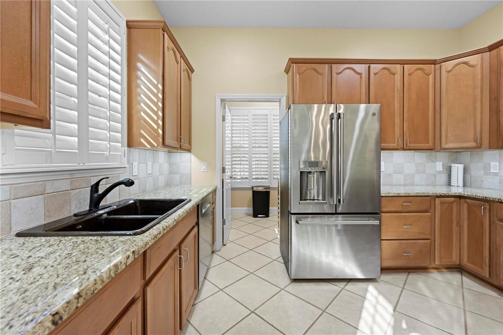 5446 Bluepoint Drive Port Richey, FL 34668 - Photo 39 of 68 a kitchen with granite countertop a refrigerator and a sink