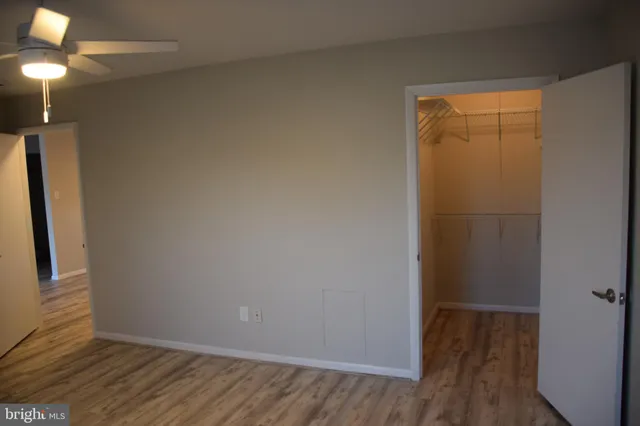 a view of small space with wooden floor and fan