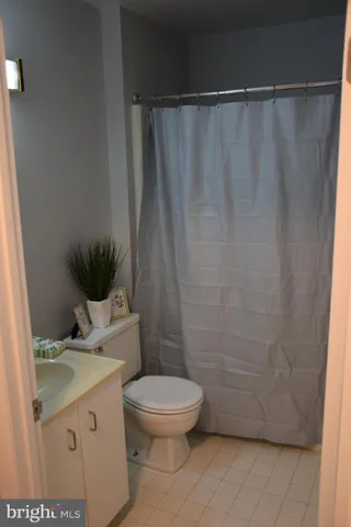 a bathroom with a granite countertop toilet and a sink