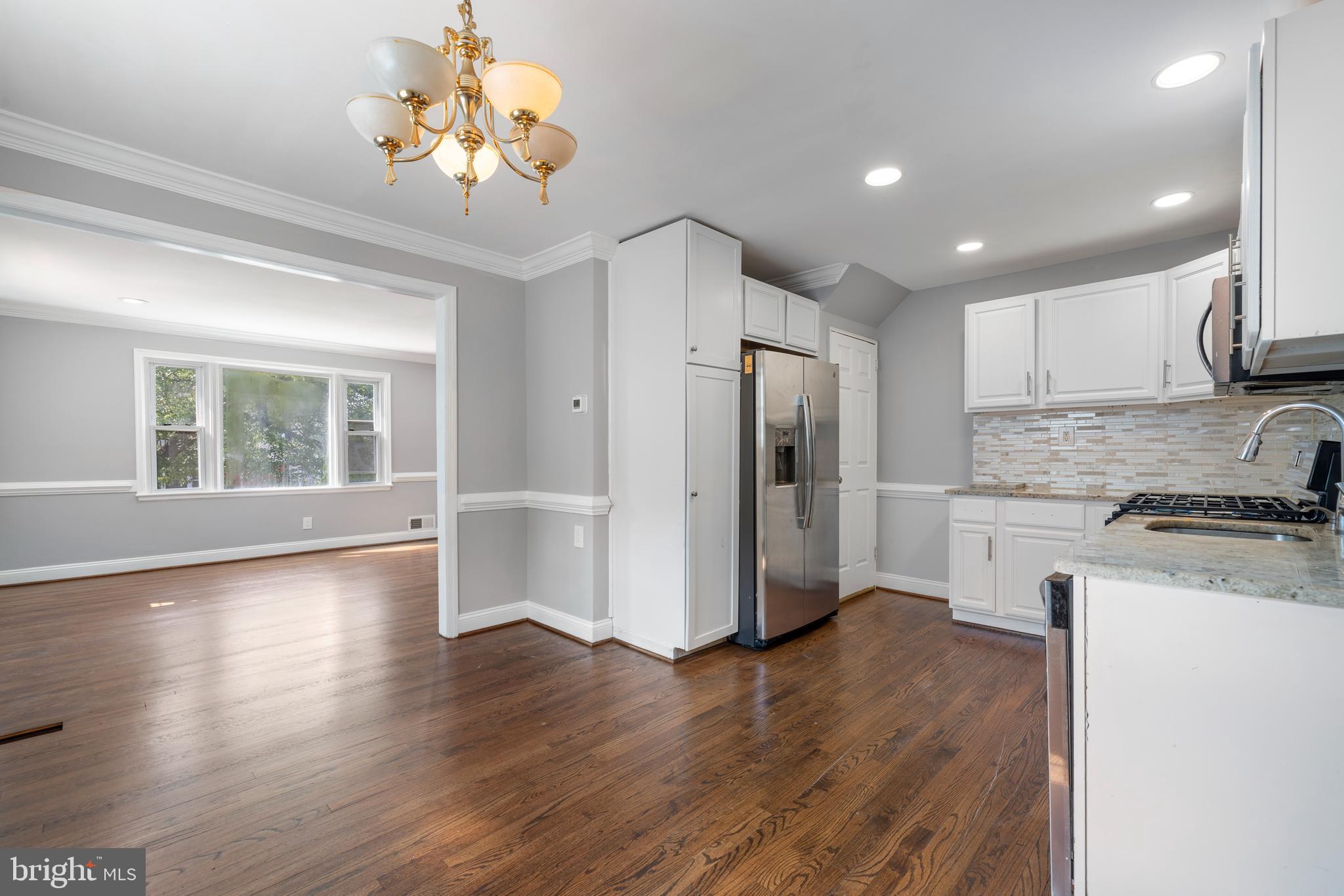 12025 Claridge Road Silver Spring, MD 20902 - Photo 7 of 25 a view of a kitchen with a stove wooden cabinet and a refrigerator