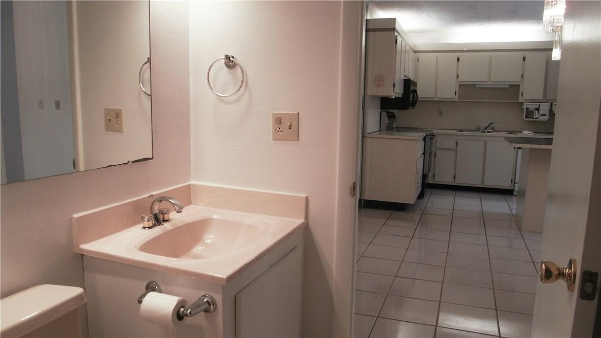 22188 Boca Rancho Drive, Unit D Boca Raton, FL 33428 - Photo 20 of 22 a bathroom with a sink a toilet and mirror