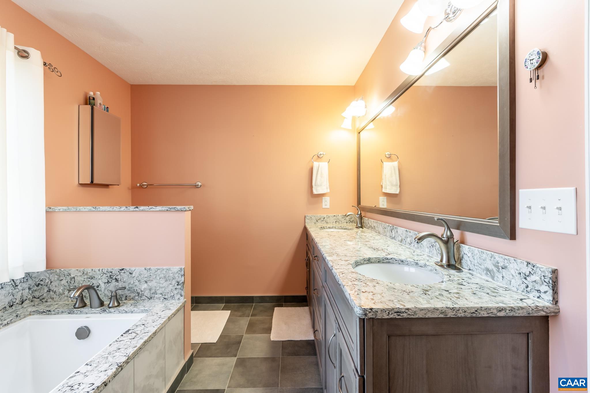 654 Saddleback Road Stanardsville, VA 22973 - Photo 25 of 75 a bathroom with a granite countertop sink and a bathtub