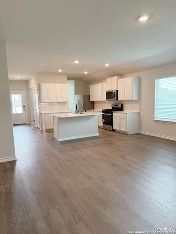 a large kitchen with a table and chairs in it