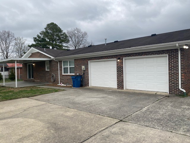 607 Adams Street Manchester, TN 37355 - Photo 1 of 14 a front view of a house with a yard and garage
