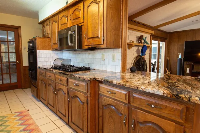 a kitchen with stainless steel appliances granite countertop a sink stove and cabinets