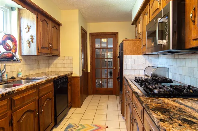 a kitchen with stainless steel appliances granite countertop a stove a sink and a refrigerator