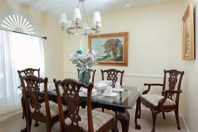 a view of a dining room with furniture a chandelier and wooden floor