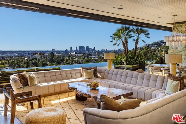 a roof deck with couches and potted plants