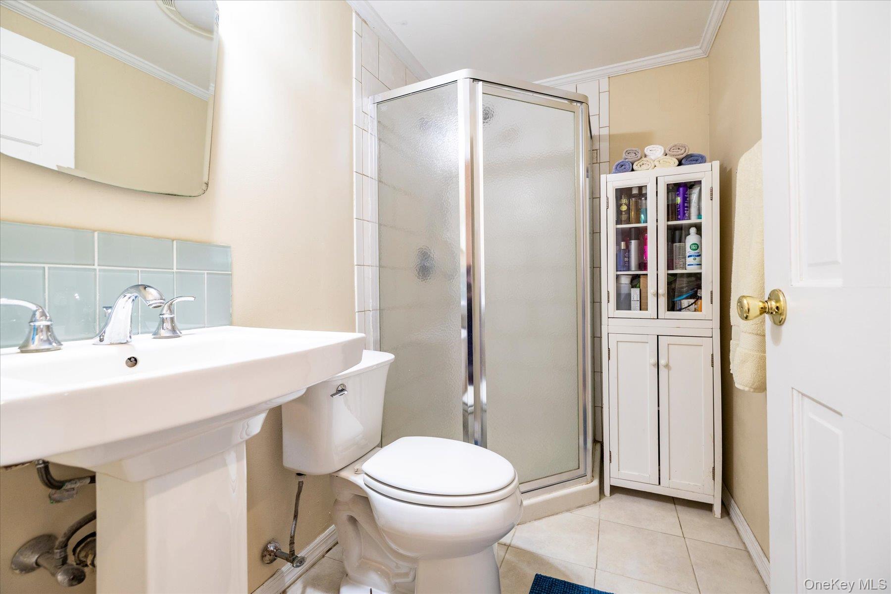 11 Maple Street Malverne, NY 11565 - Photo 12 of 18 a bathroom with a sink toilet and shower