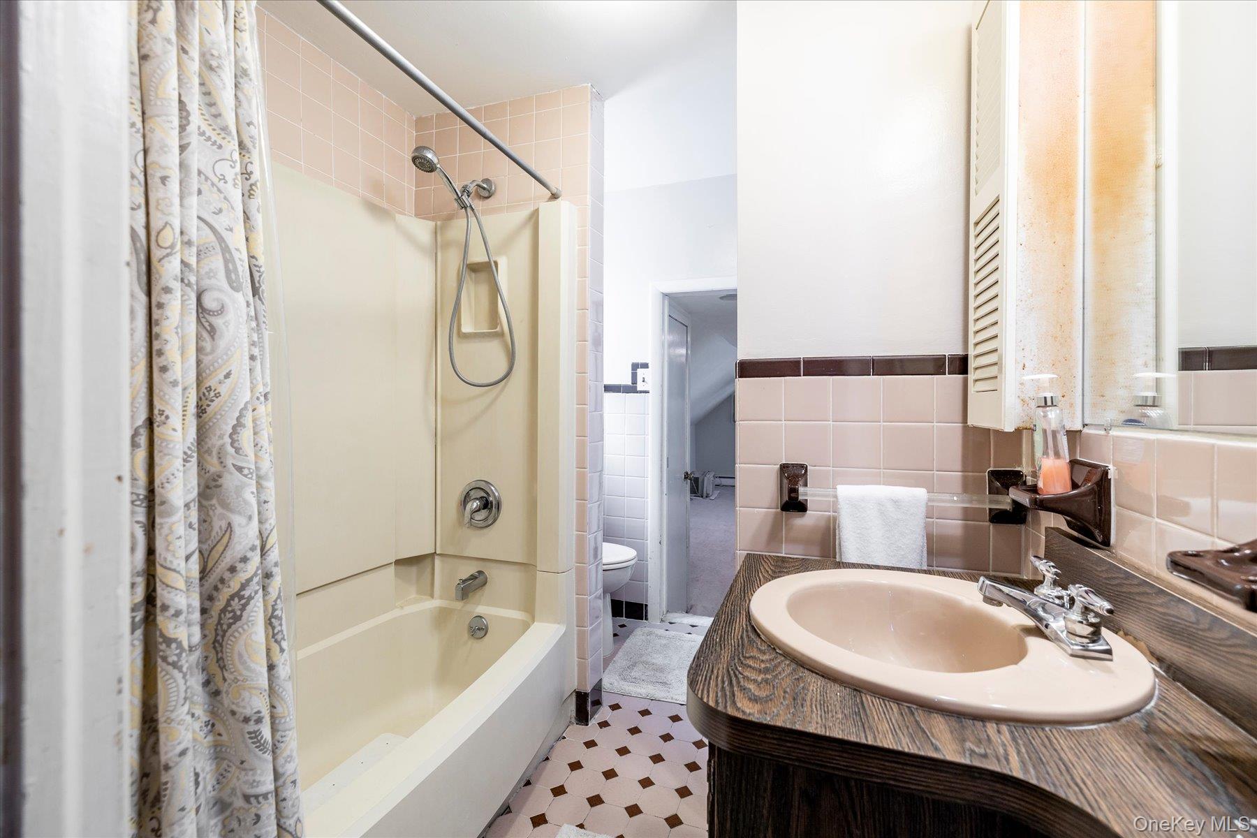 11 Maple Street Malverne, NY 11565 - Photo 16 of 18 a bathroom with a sink double vanity and a bathtub
