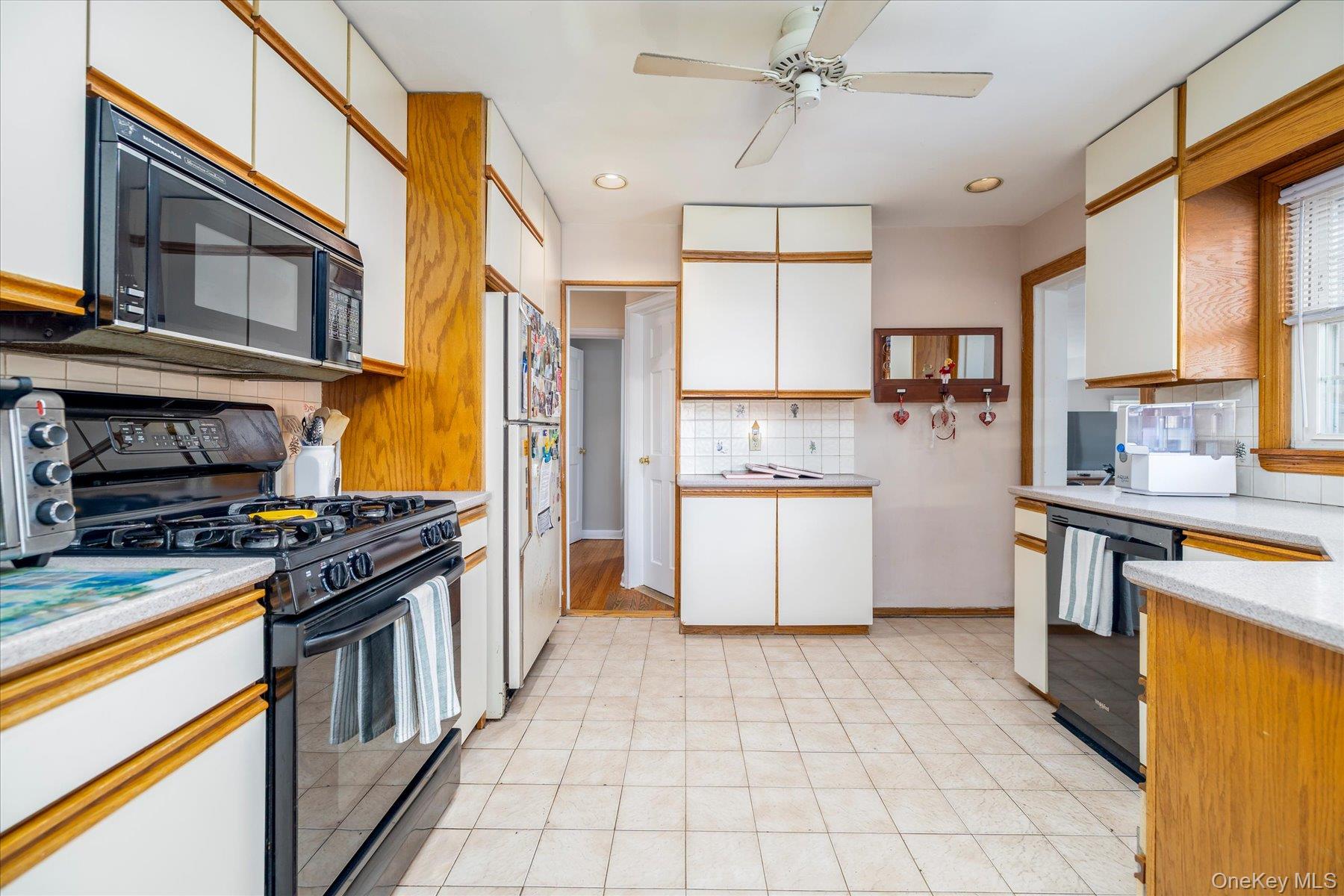 11 Maple Street Malverne, NY 11565 - Photo 7 of 18 a kitchen with stainless steel appliances granite countertop a stove top oven a sink a counter space and cabinets