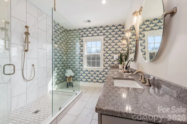 a bathroom with double vanity sinks and two mirror