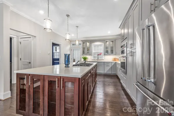 a kitchen with kitchen island a counter top space a sink stainless steel appliances and cabinets