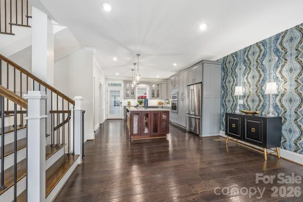 a living room with stainless steel appliances furniture and a kitchen view