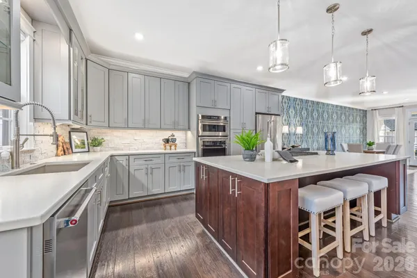 a kitchen with stainless steel appliances granite countertop a sink a stove and a refrigerator