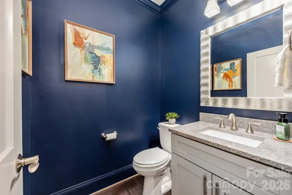 a bathroom with a granite countertop toilet sink and mirror
