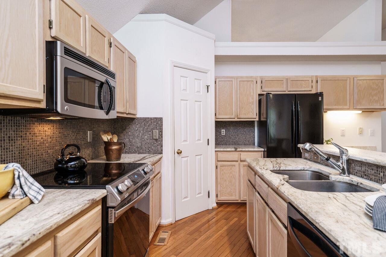 5305 Calverton Drive Raleigh, NC 27613 - Photo 12 of 34 a kitchen that has a sink and a stove top oven