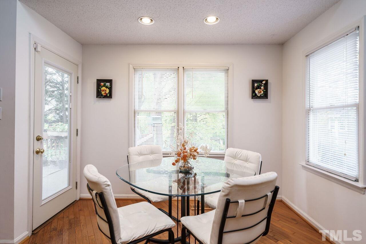 5305 Calverton Drive Raleigh, NC 27613 - Photo 13 of 34 a view of a dining room with furniture window and wooden floor