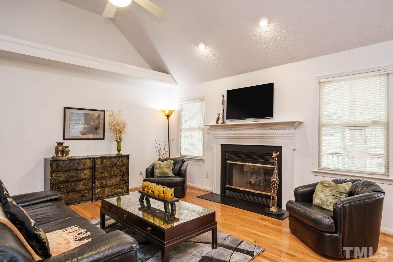 5305 Calverton Drive Raleigh, NC 27613 - Photo 15 of 34 a living room with furniture a flat screen tv and a fireplace