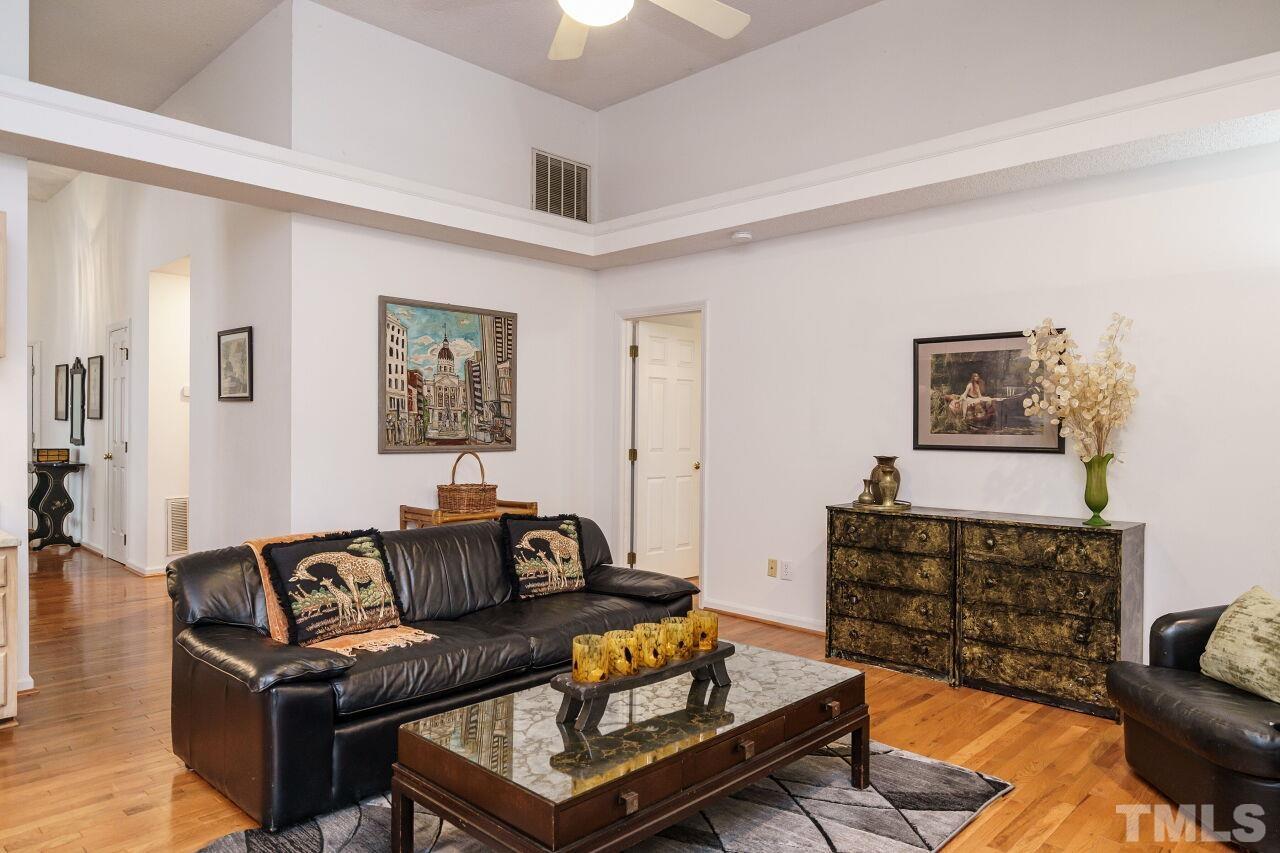 5305 Calverton Drive Raleigh, NC 27613 - Photo 17 of 34 a living room with furniture a couch and a bookshelf with wooden floor