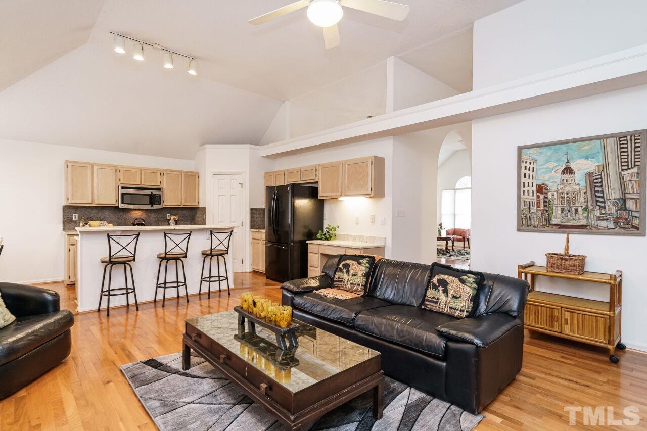 5305 Calverton Drive Raleigh, NC 27613 - Photo 18 of 34 a living room with furniture a flat screen tv and kitchen view