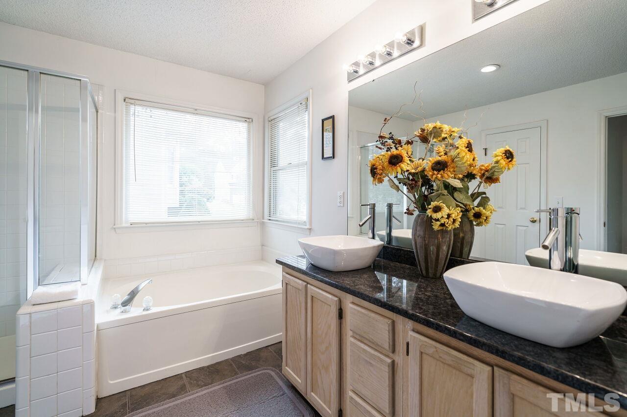 5305 Calverton Drive Raleigh, NC 27613 - Photo 21 of 34 a bathroom with a tub sink and mirror