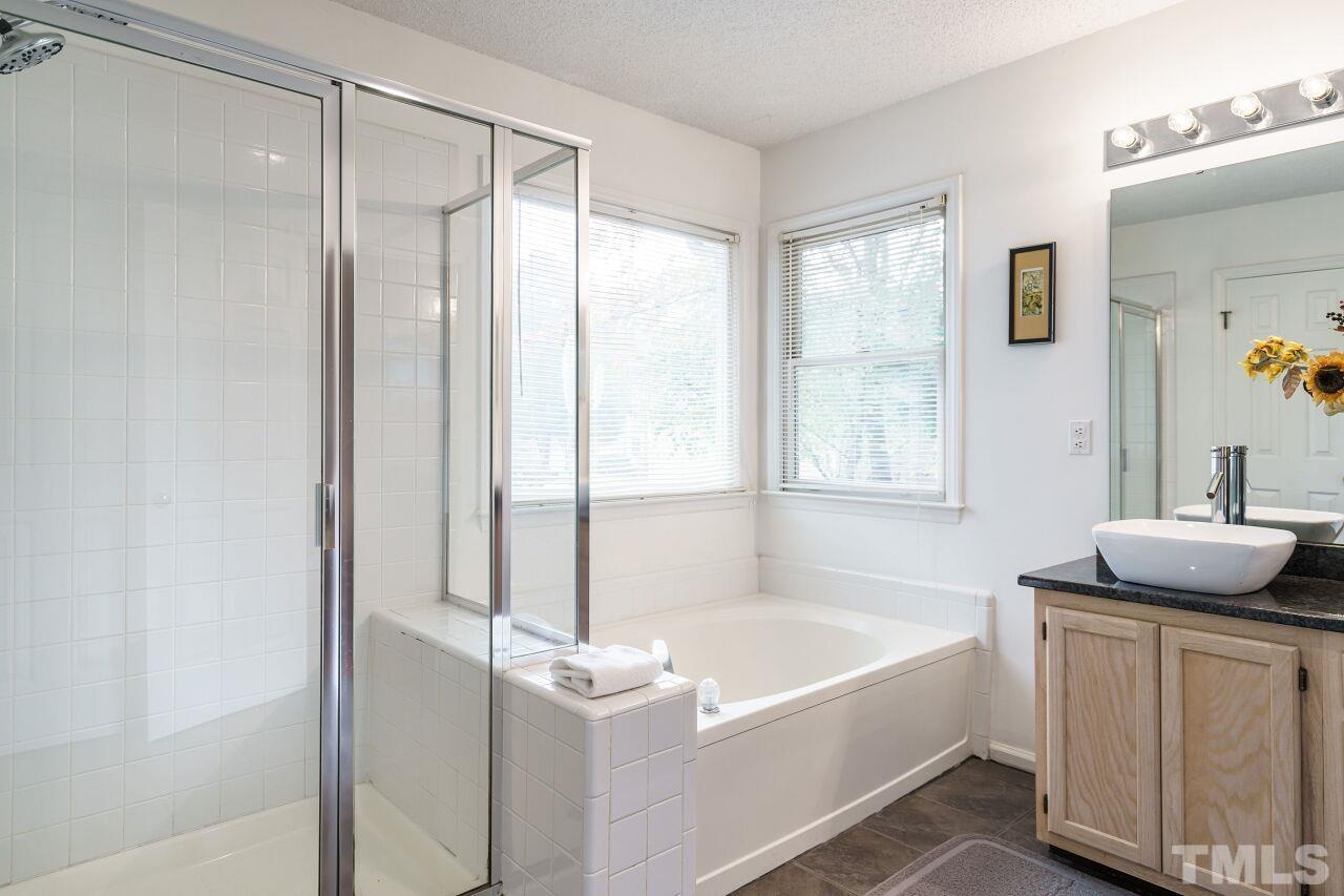5305 Calverton Drive Raleigh, NC 27613 - Photo 22 of 34 a bathroom with a tub sink and mirror