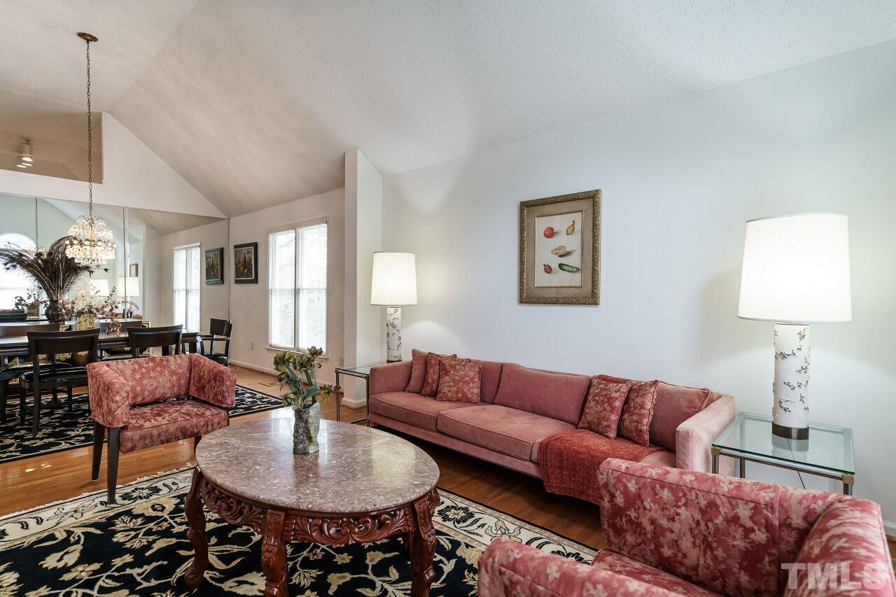 5305 Calverton Drive Raleigh, NC 27613 - Photo 4 of 34 a living room with furniture a lamp and a chandelier