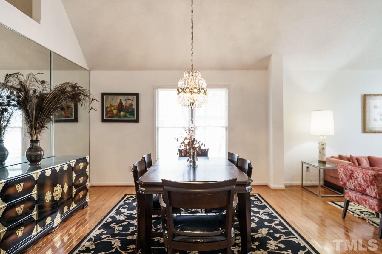 5305 Calverton Drive Raleigh, NC 27613 - Photo 9 of 34 a dining room with furniture a chandelier and window