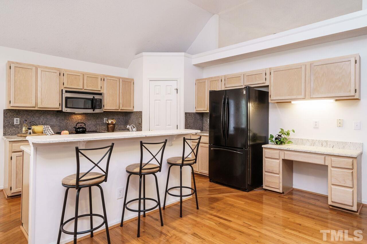 5305 Calverton Drive Raleigh, NC 27613 - Photo 10 of 34 a kitchen with stainless steel appliances granite countertop a stove a refrigerator a microwave a sink and white cabinets