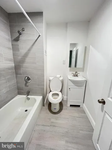 a bathroom with a toilet sink a mirror and bathtub