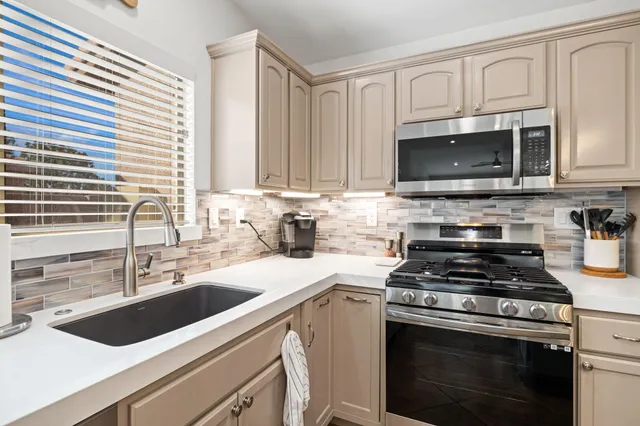 a kitchen with cabinets appliances a sink and a counter top space