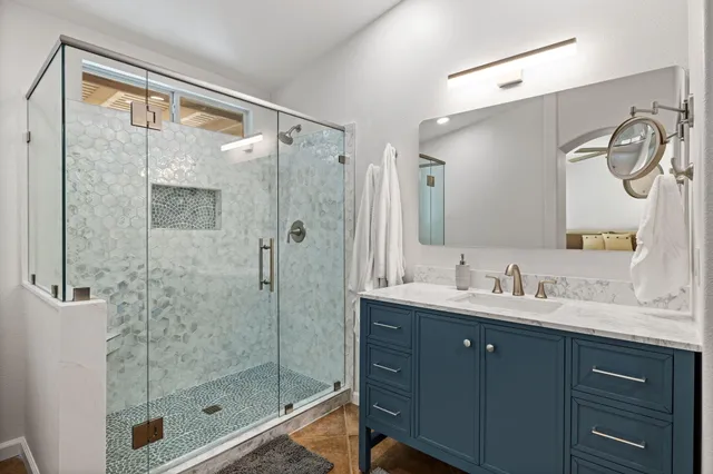 a bathroom with a shower sink and mirror