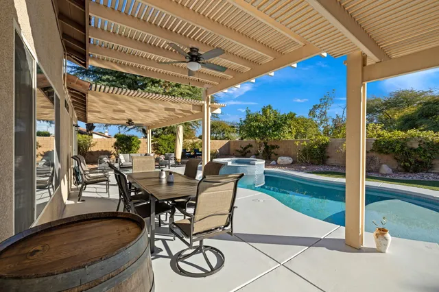 a view of a patio with table and chairs potted plants with wooden floor and fence