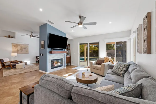 a living room with furniture a fireplace and a flat screen tv